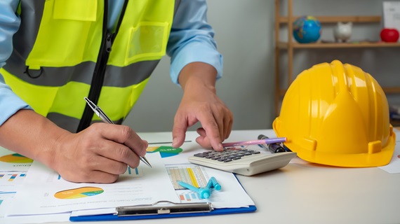 A foreman sits at a desk in an office
