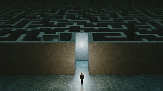 Businessman standing in front of the entrance to the maze