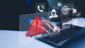 Cybersecurity warning graphic showing a scam alert on a laptop.