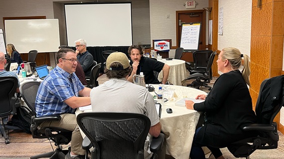 Meeting/training session with attendees seated around tables