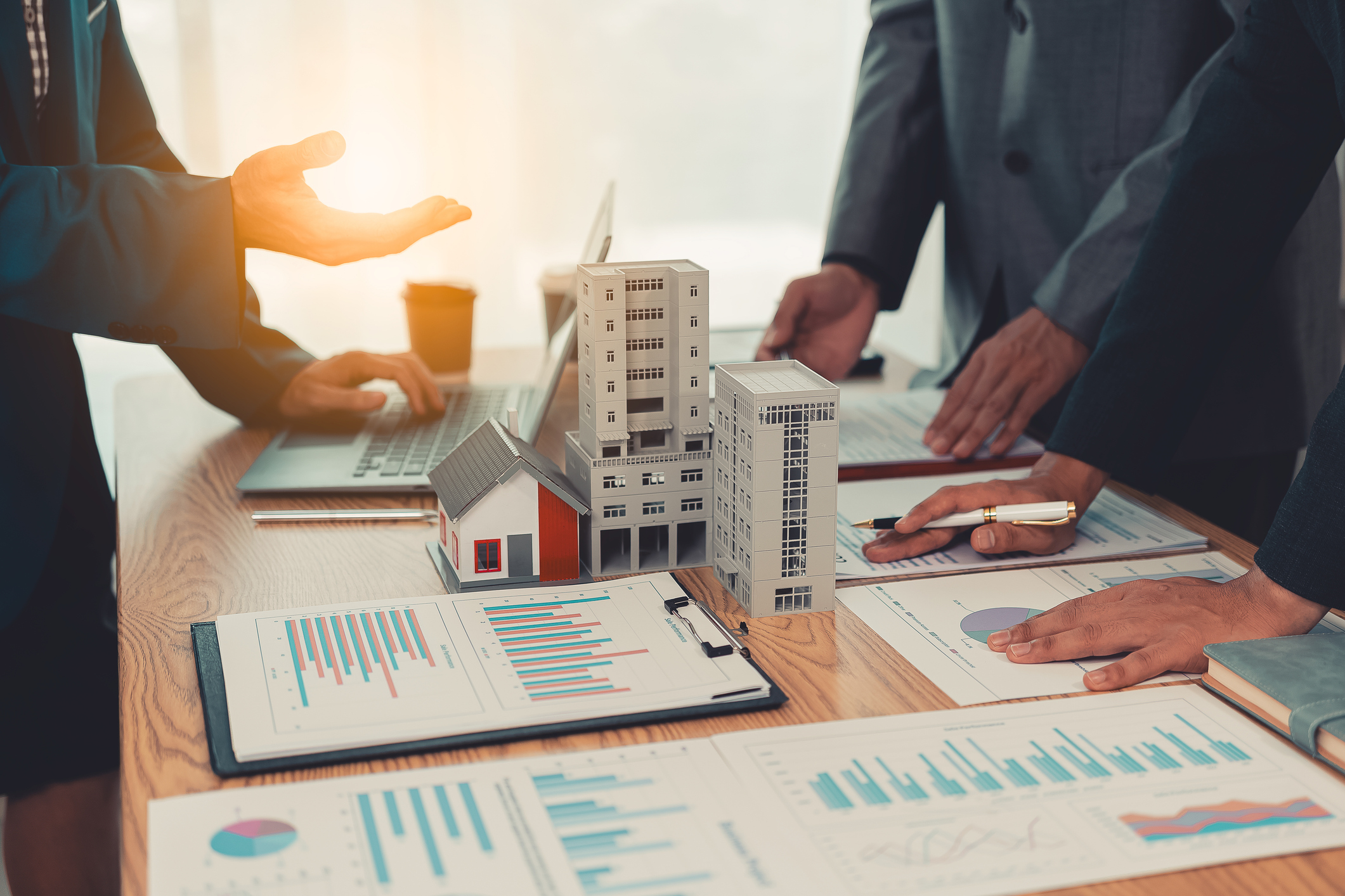 Professionals reviewing an office building model and plans